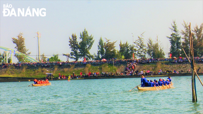 A large number of people cheering for the boat race on the Cu De River