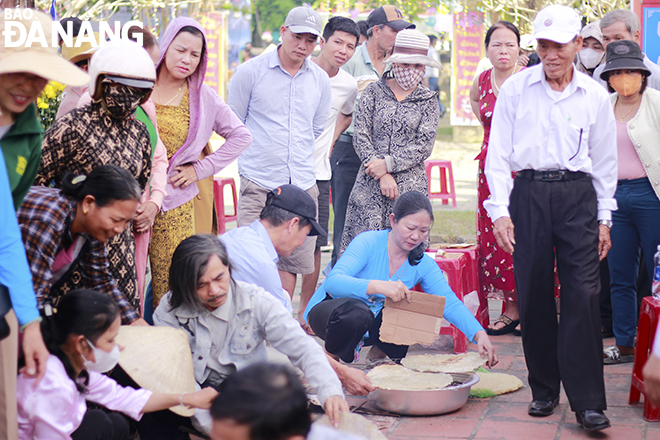 Người dân cổ vũ cho các đội thi nướng bánh tráng tại lễ hội.