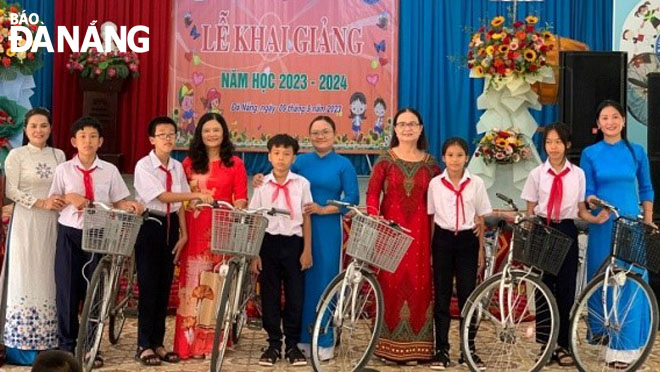 Vice President of the Da Nang Association for Supporting Disadvantaged Women and Children Do Thi Kinh Linh (4th, left) gives gifts to children of the Village of Hope.