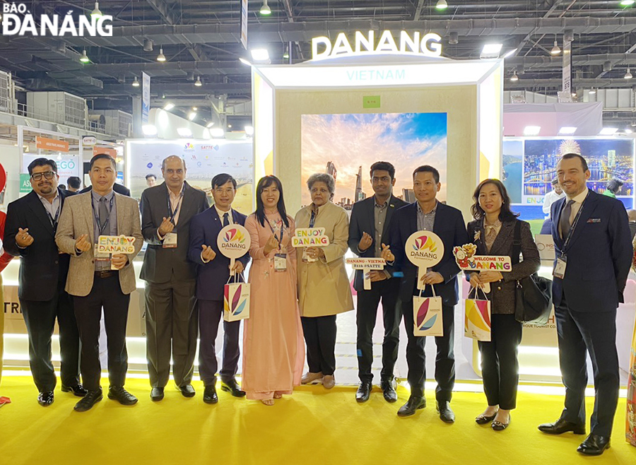 Các đại biểu, khách tham dự hội chợ chụp hình cùng đại diện Sở du lịch Đà Nẵng tại gian hàng Da Nang FantastiCity. Ảnh: TTXTDL