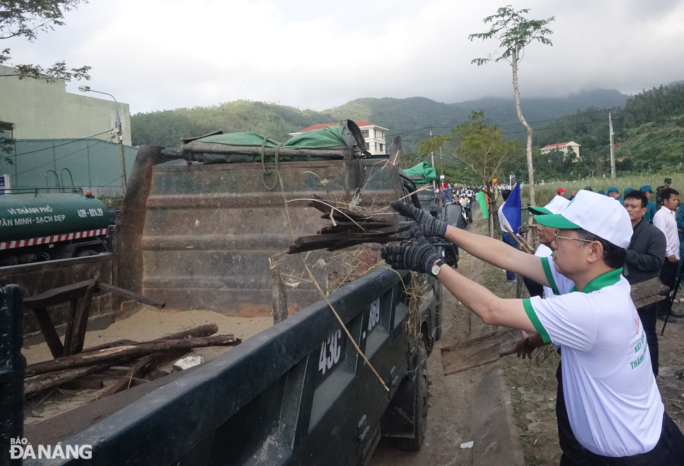 Bí thư Thành ủy Nguyễn Văn Quảng cùng đưa rác lên xe vận chuyển để chở đi xử lý. Ảnh: HOÀNG HIỆP