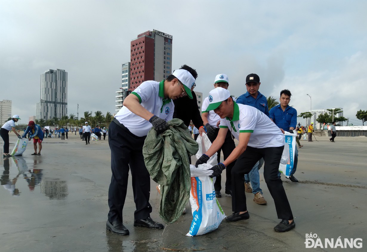 Bí thư Thành ủy Nguyễn Văn Quảng cùng tham gia làm sạch bãi biển. Ảnh: HOÀNG HIỆP