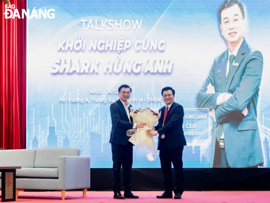 Lãnh đạo Trường đại học Kinh tế (Đại học Đà Nẵng) tặng hoa cho ông Lê Hùng Anh (bên phải) là nhà sáng lập kiêm Giám đốc điều hành tại Công ty Cổ phần Tập đoàn Bin Corporation.