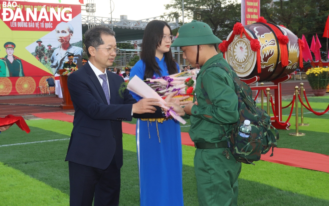 Bí thư Thành ủy Nguyễn Văn Quảng tặng hoa động viên tân binh lên đường nhập ngũ. Ảnh: NGỌC HÀ