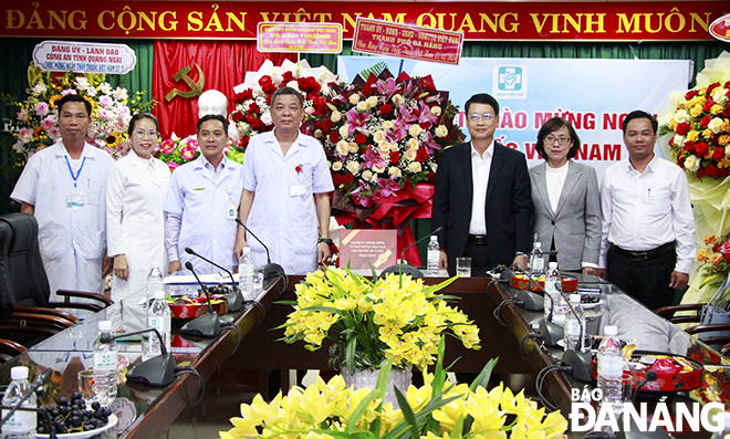 Chủ tịch Ủy ban MTTQ Việt Nam thành phố Ngô Xuân Thắng tặng hoa chúc mừng tập thể lãnh đạo, y bác sĩ, điều dưỡng Bệnh viện 199. Ảnh: X.D