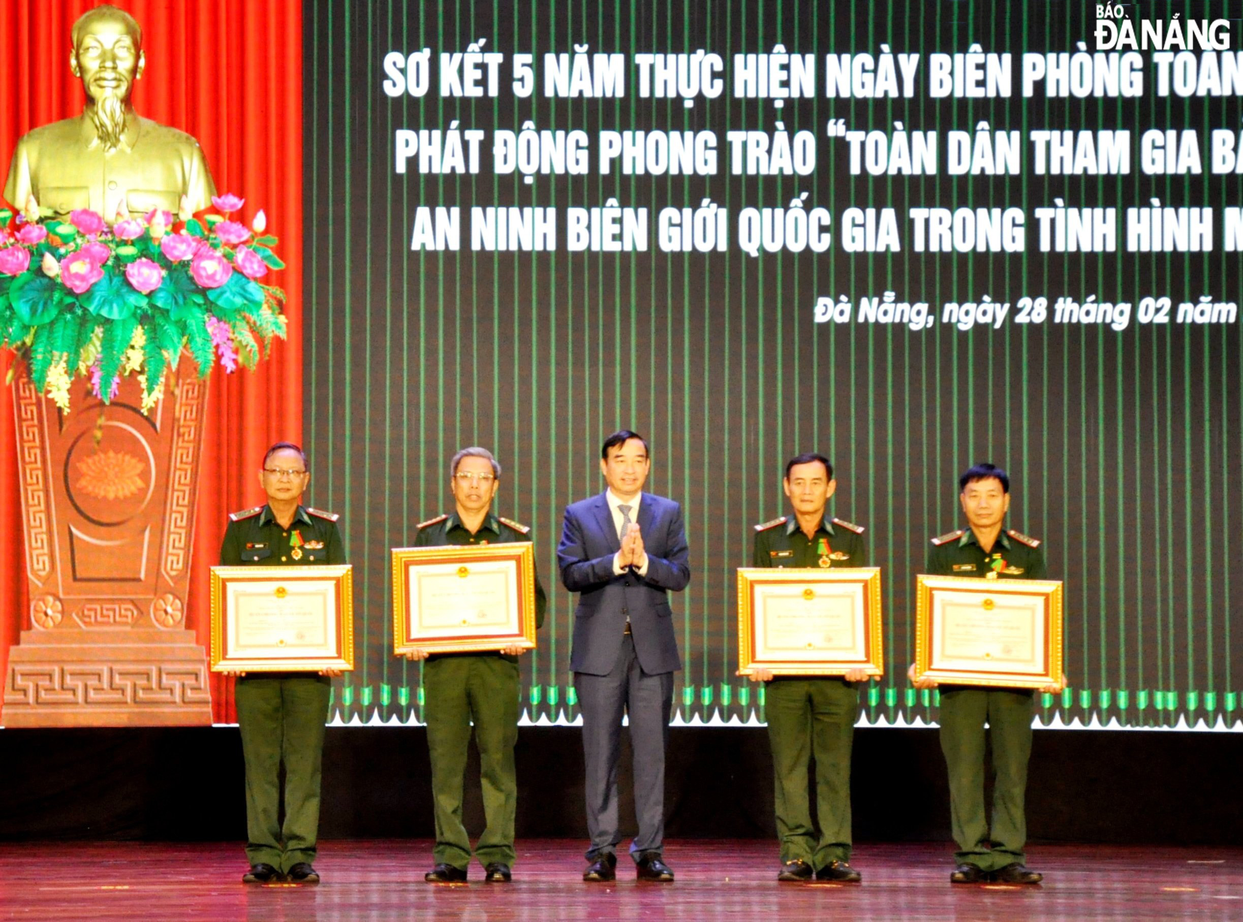 Under the authorisation of the President, Chairman of the municipal People's Committee Le Trung Chinh (middle) awards the Second and Third-Class Fatherland Defence Medals to individuals. Photo: LE HUNG