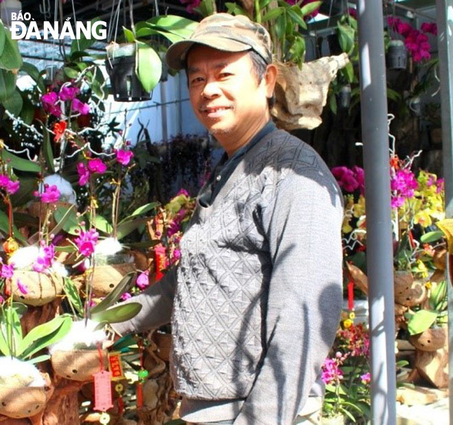 Mr Nguyen Van Tinh with his grafted orchid artworks on driftwood.