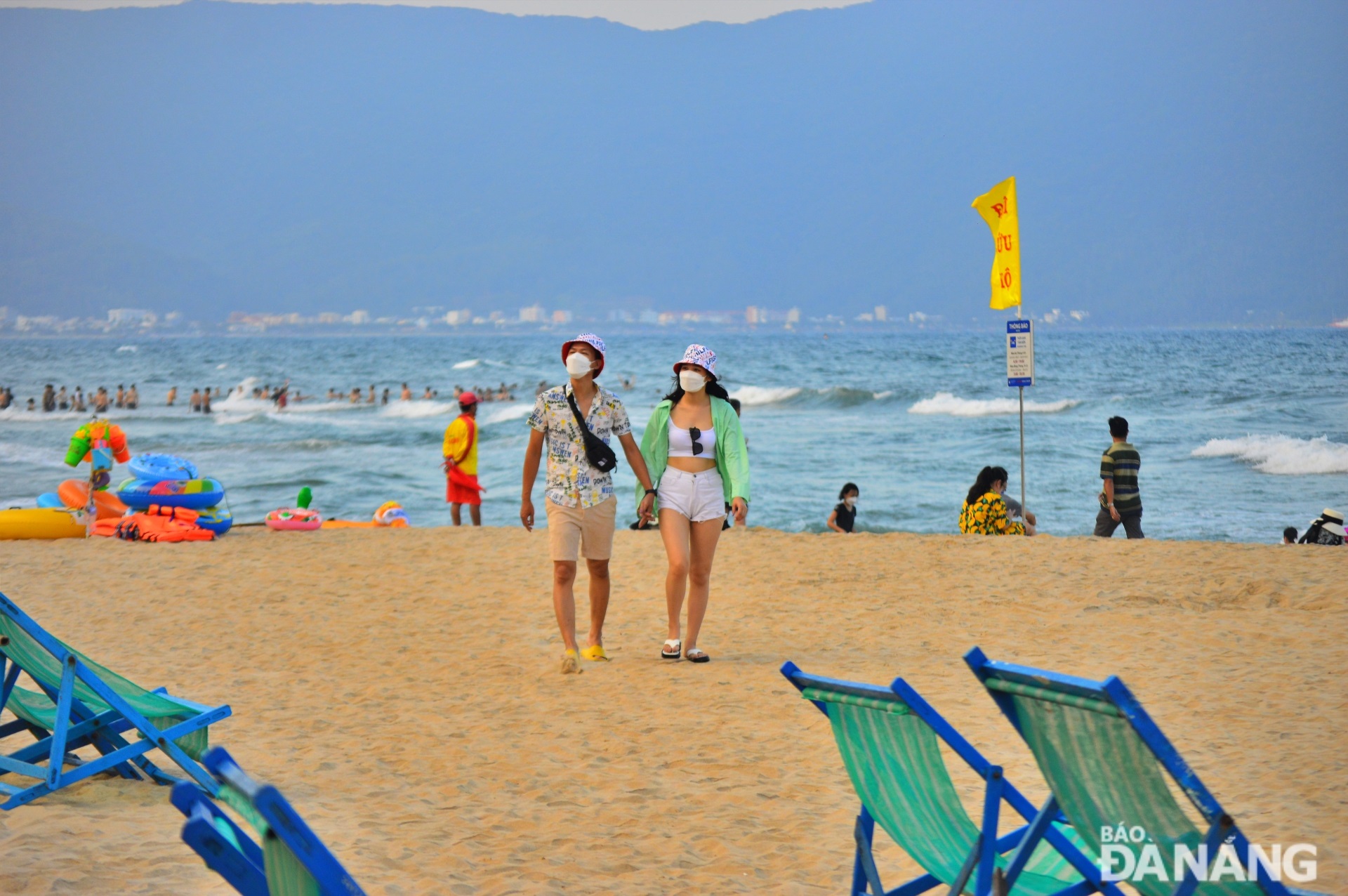 Tourists freely stroll along the beach