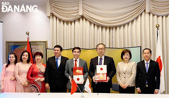 Japanese Ambassador to Viet Nam Yamada Takio (3rd, right) and Chairman of Hoa Vang District People's Committee Phan Van Ton (5th, left) at the signing ceremony for sponsorship contracts. Photo: P.V