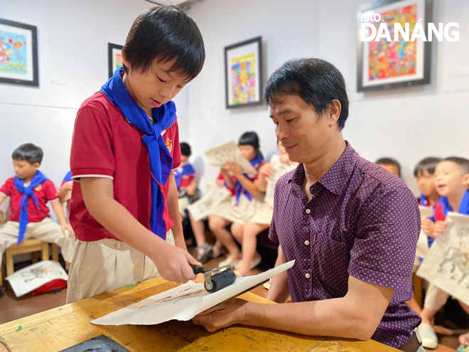 Many young tourists experiencing Dong Ho painting printing techniques at the Da Nang Museum of Fine Arts. Photo: H.L