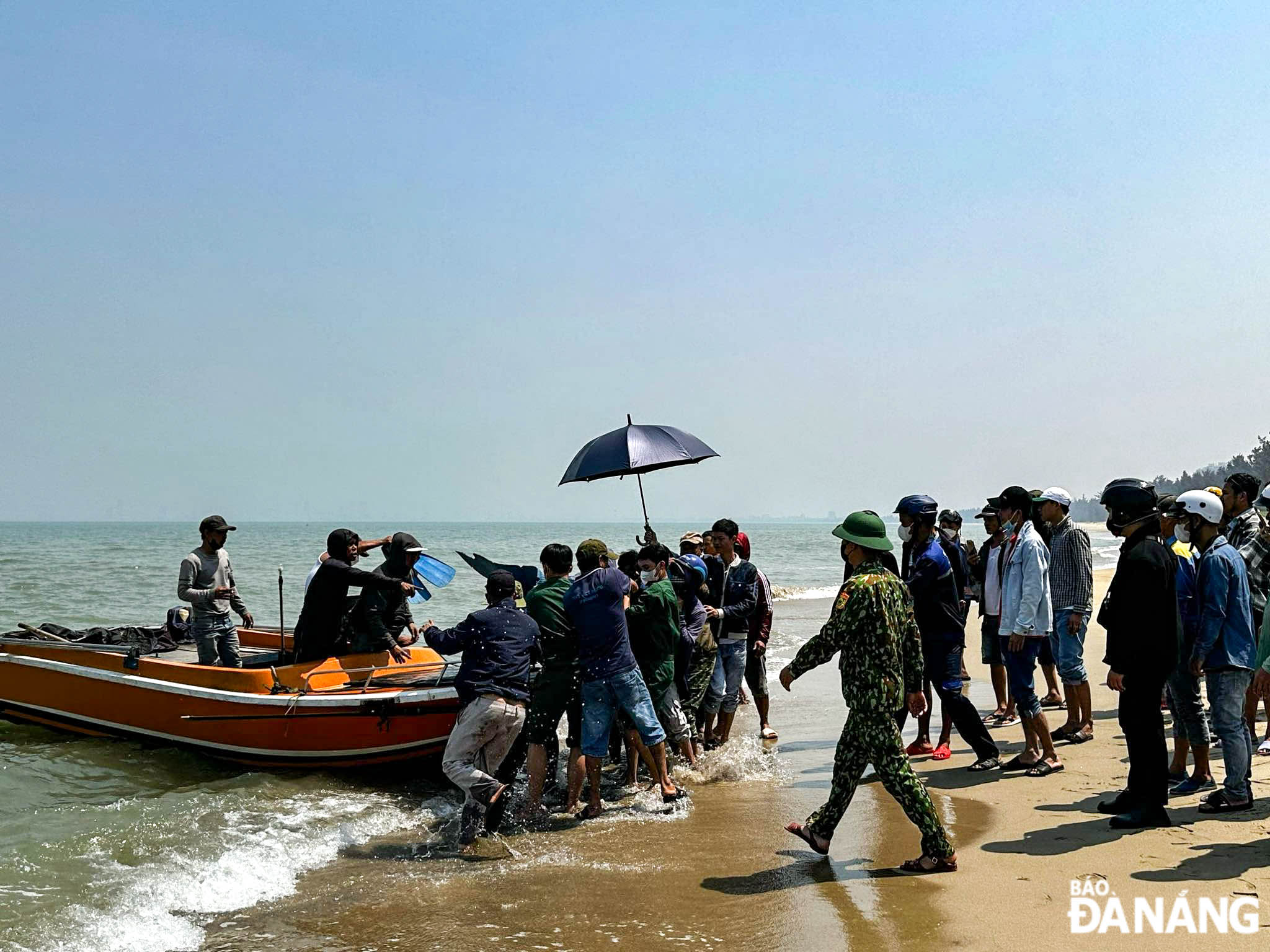 Lực lượng Biên phòng thành phố phối hợp với người dân làng Nam Ô đưa thi thể nạn nhân xấu số vào bờ vào khoảng 11 giờ ngày 3-6.