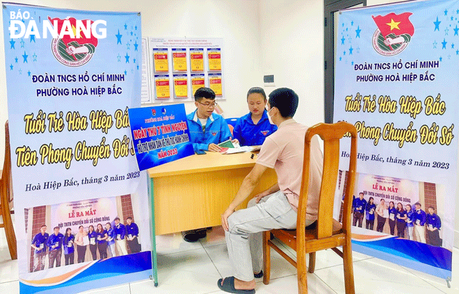 Đoàn viên thanh niên phường Hòa Hiệp Bắc (quận Liên Chiểu) hướng dẫn người dân sử dụng dịch vụ công trực tuyến. Ảnh: T.H