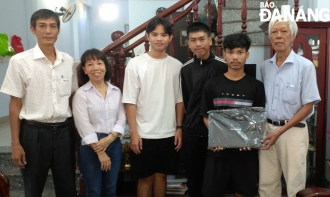 Mr. Dinh Xe (right) gifting a computer to Khamphen - Lưu.