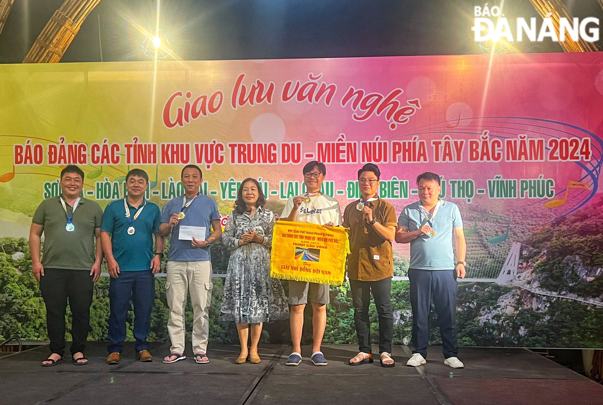 Phó Tổng biên tập Báo Đà Nẵng Trần Thị Thu Thuỷ trao cờ và huy chương bạc cho các vận động viên nội dung trượt cầu vồng nam trong tối 23-3. Ảnh: DUYÊN ANH