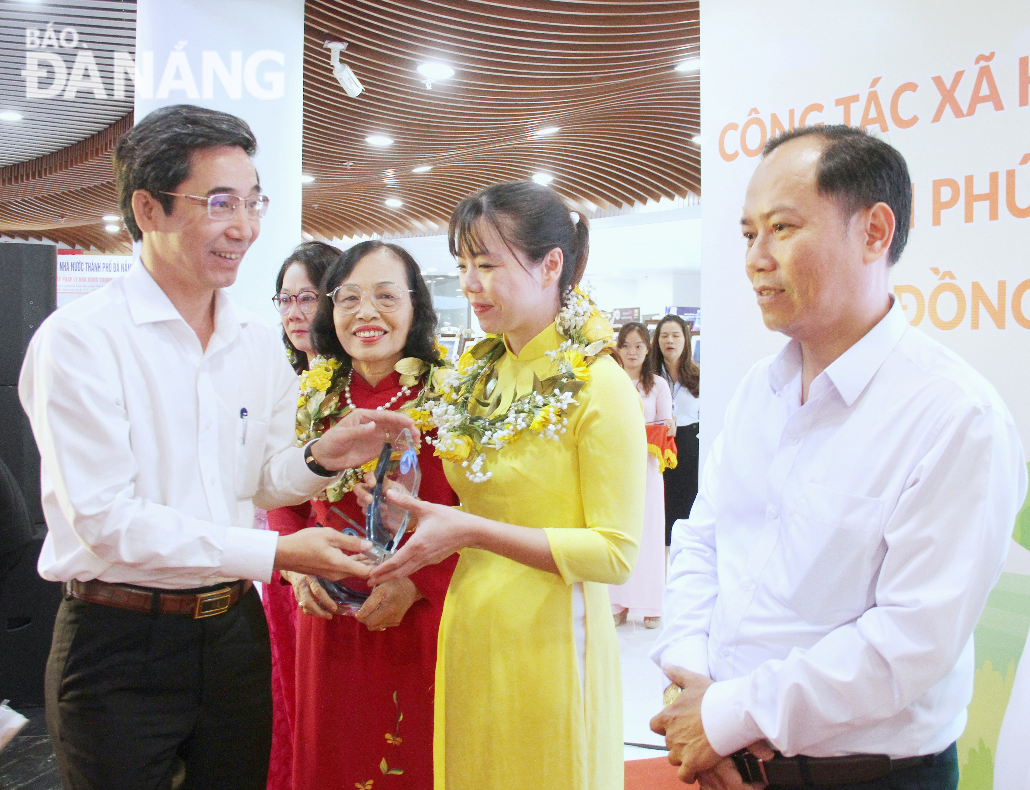 Vice Chairman of the Da Nang People's Committee Tran Chi Cuong (left) presenting flowers and symbols to individuals in recognition of their great involvement in social work. Photo: L.P