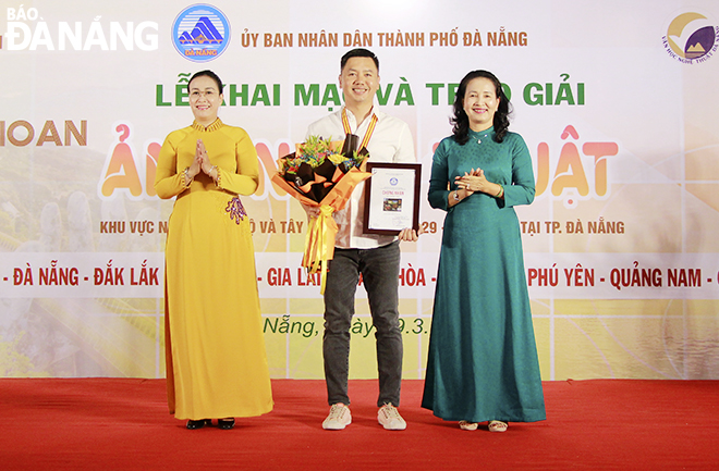 Vice Chairwoman of the Da Nang People's Council Nguyen Thi Anh Thi (left) and Chairman of the Viet Nam Association of Photographic Artists Tran Thi Thu Dong presenting the first prize to Nguyen Ngoc Hoa from Gia Lai province for his set of photos entitled ‘Vietnamese Coffee’. Photo: X.D