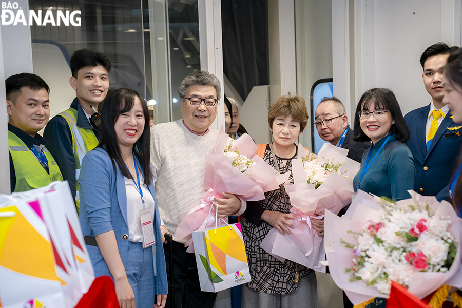 Representatives of the Da Nang Tourism Promotion Center and the city branch of the Vietravel presenting flowers and gifts to tourists on the charter flight. Photo: THU HA