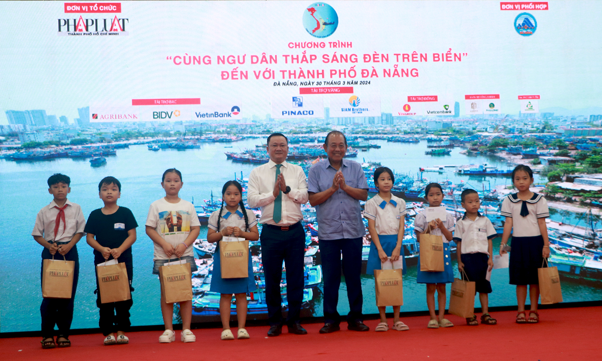 nguyên Ủy viên Bộ Chính trị, nguyên Phó Thủ tướng Thường trực Chính phủ Trương Hòa Bình (thứ 5, bên phải sang) trao học bổng cho con em của gia đình ngư dân nỗ lực vượt khó, học giỏi. Ảnh: VĂN HOÀNG
