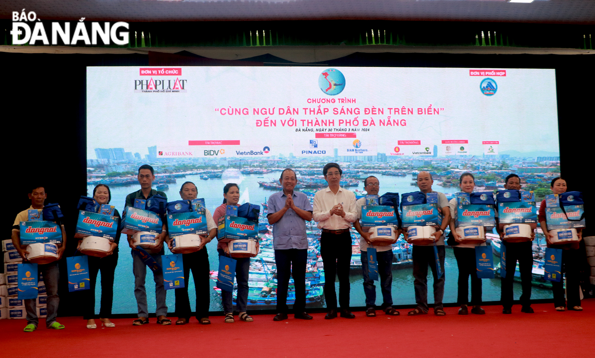 Former Politburo member, former Permanent Deputy Prime Minister Truong Hoa Binh (6th, left) and Vice Chairman of the Da Nang People's Committee Tran Chi Cuong (7th, left) giving gifts to fishermen. Photo: VAN HOANG