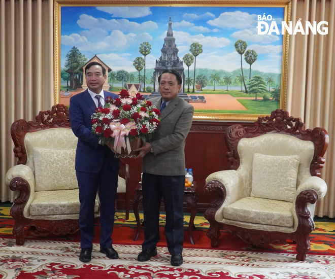 Chairman of the Da Nang People's Committee Le Trung Chinh presenting flowers to wish New Year to Governor of Laos’ Savannakhet Province Bounchom Oubonpaserth on the occasion of Bunpimay Tet. PHOTO: S.TRUNG