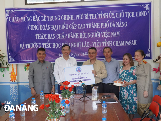 Chairman of the Da Nang People's Committee Le Trung Chinh (second, left) donating VND50 million to support the Vietnamese Association of Champasak Province. PHOTO: S. TRUNG