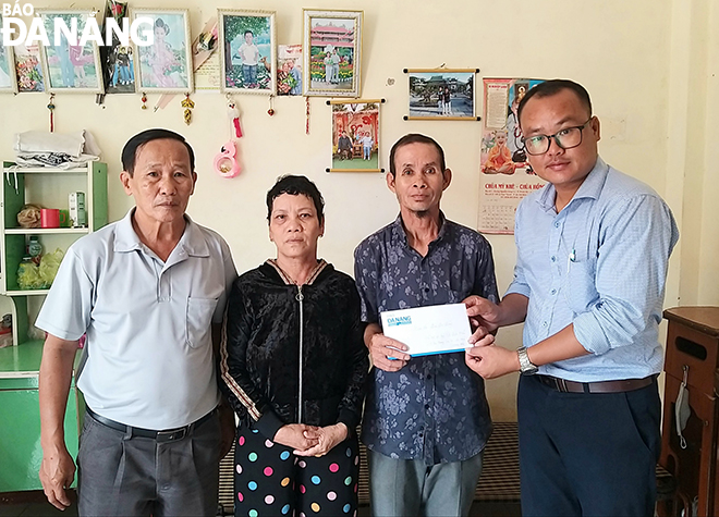 A representative of the Weekend - Readers Department under the Da Nang Newspaper (first right) handing a cash donation raised from the newspaper’s readers to Mr. Man and Mrs. Lan (middle)