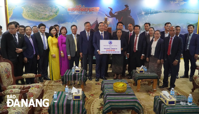 The Da Nang delegation presenting VND500 million to leaders of Attapeu Province for social security work. PHOTO: S.TRUNG