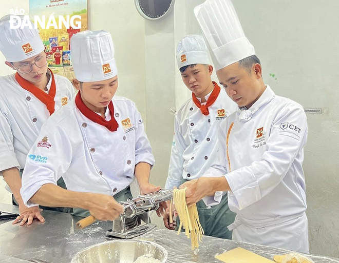 Mr. Nguyen Van Hau (first right) is instructing students to cook food