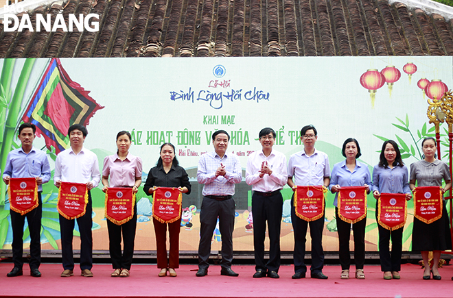Secretary of Hai Chau District Party Committee Tran Thang Loi (6th, left) and Deputy Director of the municipal Department of Culture and Sports Ha Vy (5th, left) presenting souvenir flags to participating units. Photo: X.D