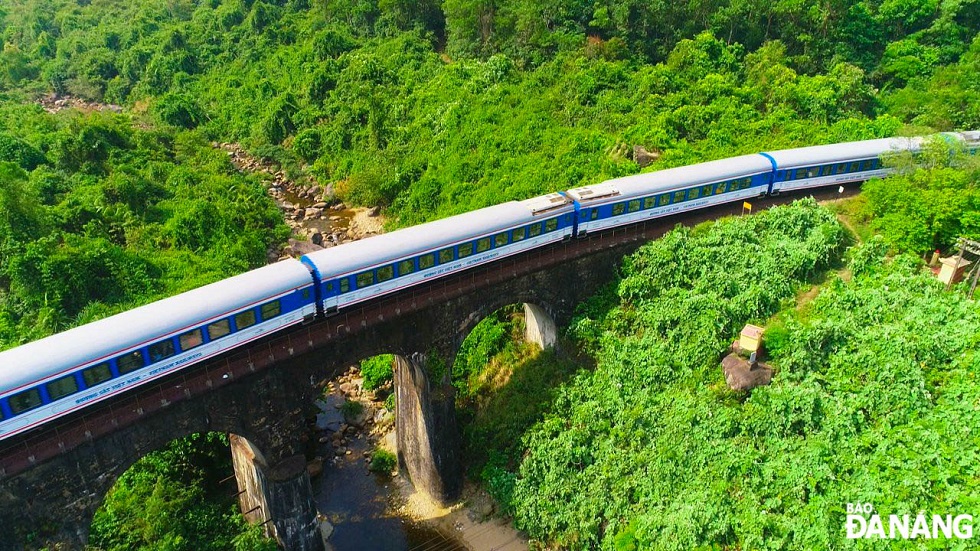 While bathing in the stream, visitors can see trains moving through the Don Ca arch bridge.