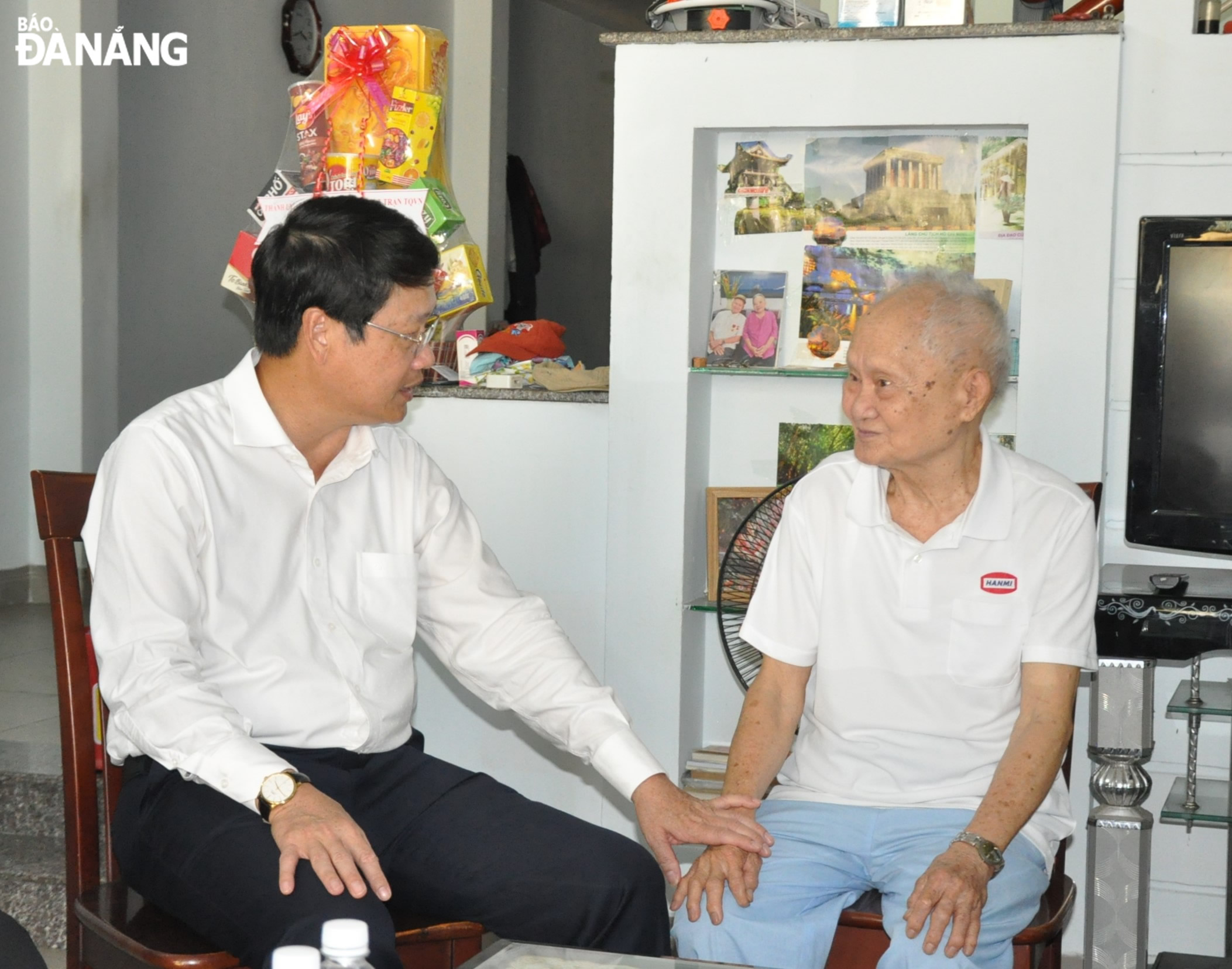 Chủ tịch Ủy ban MTTQ Việt Nam thành phố Ngô Xuân Thắng (bên trái) thăm hỏi sức khỏe ông Thái Đắc. Ảnh: LÊ HÙNG