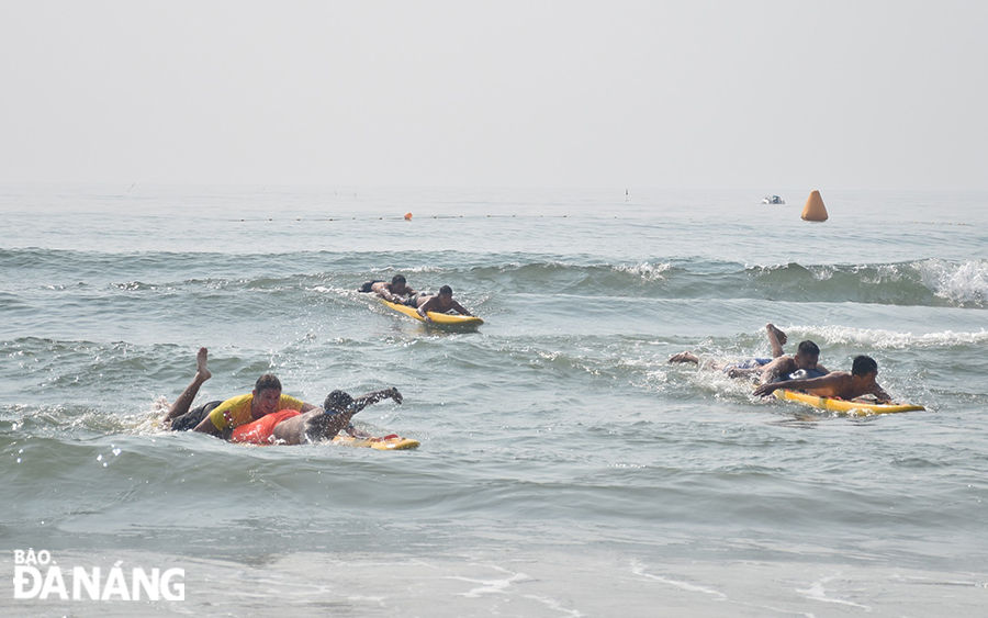 Ở nội dung lướt ván cứu hộ, các vận động viên phải bơi ra cứu hộ nạn nhân rồi đưa vào bờ. Ảnh: THU HÀ