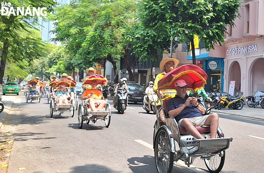 Du khách tàu biển thường lựa chọn tham quan các khu, điểm du lịch trên địa bàn thành phố. Trong ảnh: Du khách trải nghiệm tour xích lô vòng quanh thành phố. Ảnh: THU HÀ