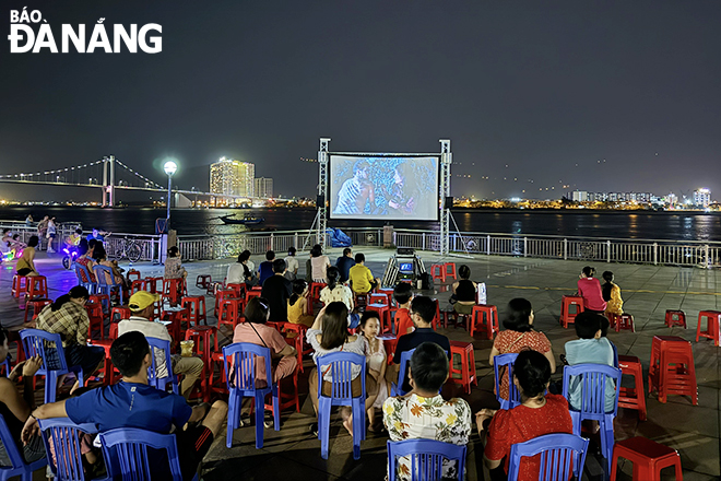 People enjoy outdoor movies on the sidewalk of Nhu Nguyet Street, Hai Chau District