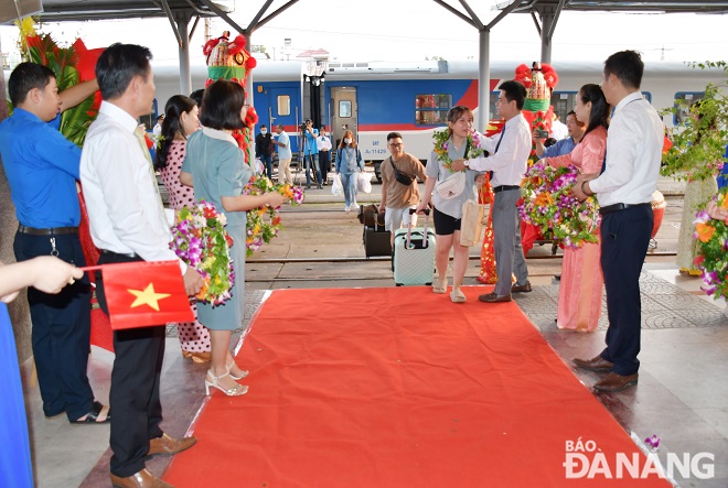 Leaders of Da Nang Railway Transport Branch giving flowers to train passengers. Photo: THANH LAN