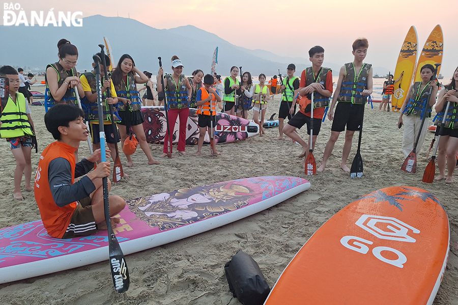 Right from the early morning, many people and tourists flock to local beaches to swim or play some beach sports such as SUP rowing. Photo: THU HA