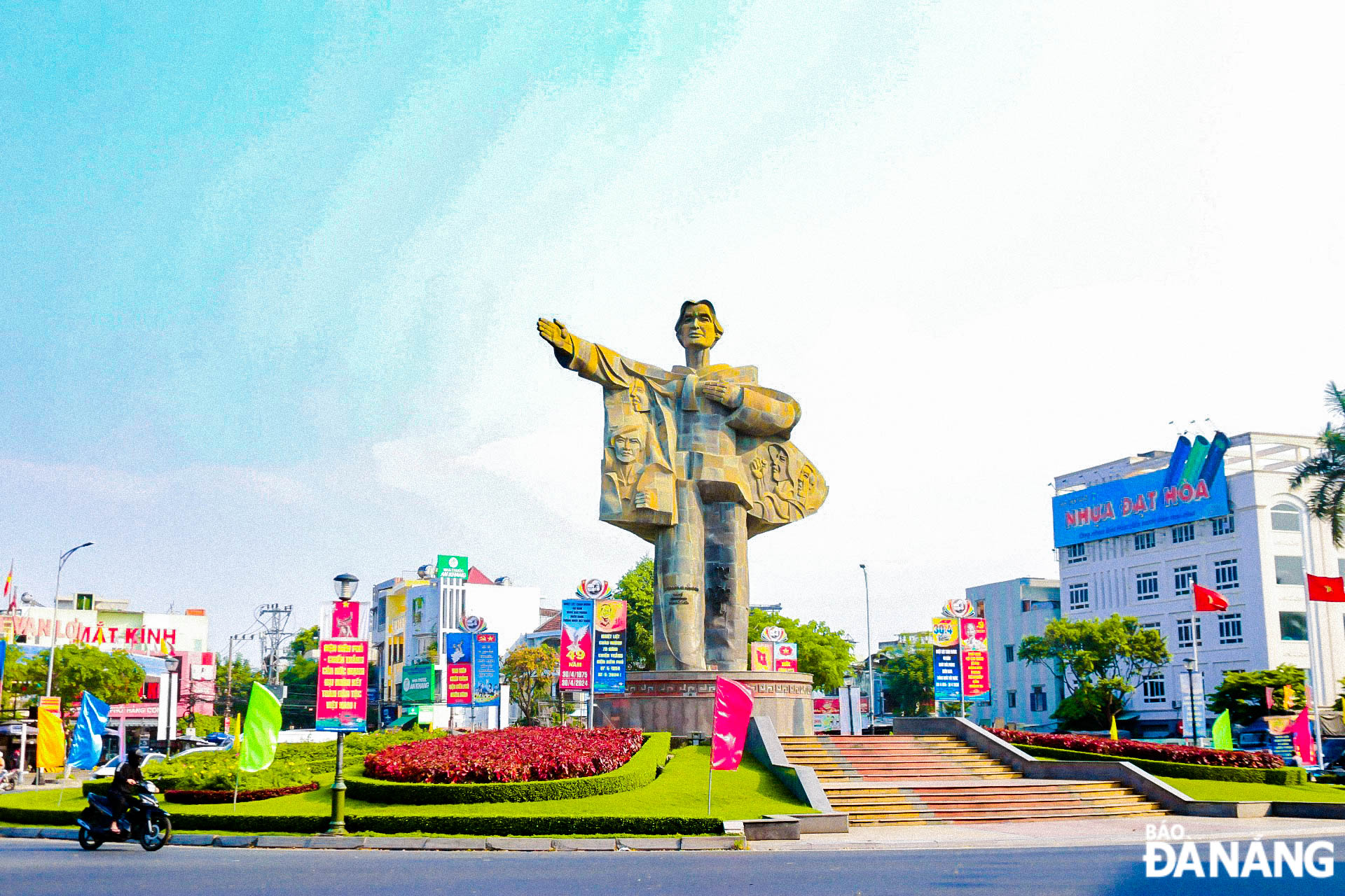 Mother Nhu's monument is decorated with flags, flowers, hoardings, and posters.