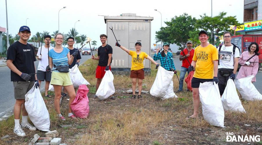 Ms. Mai Thi Kim Anh (middle), who is in charge of the Trash Hero Da Nang Group, and volunteers picking up trash to clean up the environment.