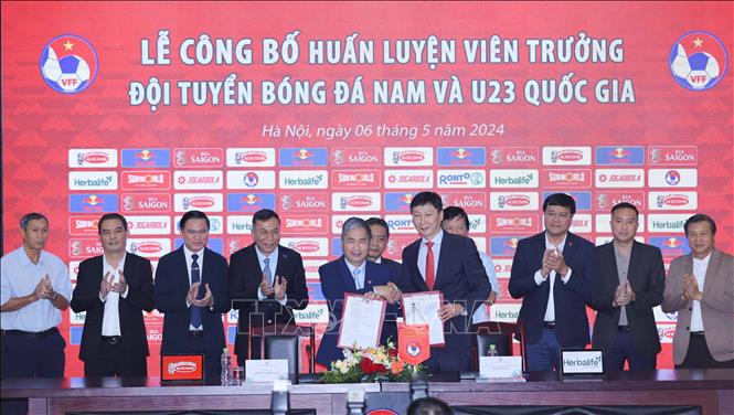 Lãnh đạo Liên đoàn Bóng đá Việt Nam (VFF) tặng hoa và áo cho HLV Kim Sang-sik. Ảnh: TTXVN