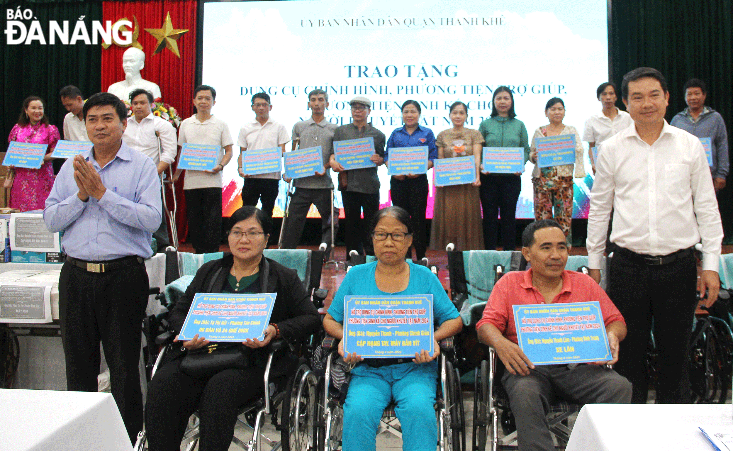 Thanh Khe District Peoples Committee Vice Chairman Nguyen Huu Cong (first row, right) gives livelihoods and wheelchairs to disabled people in the district. Photo: L.P