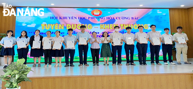 Representatives of Hai Chau District’s Hoa Cuong Bac Ward Chapter of the Da Nang Study Promotion Association awarding scholarships to poor students to prepare for their new school year. Photo: C.A