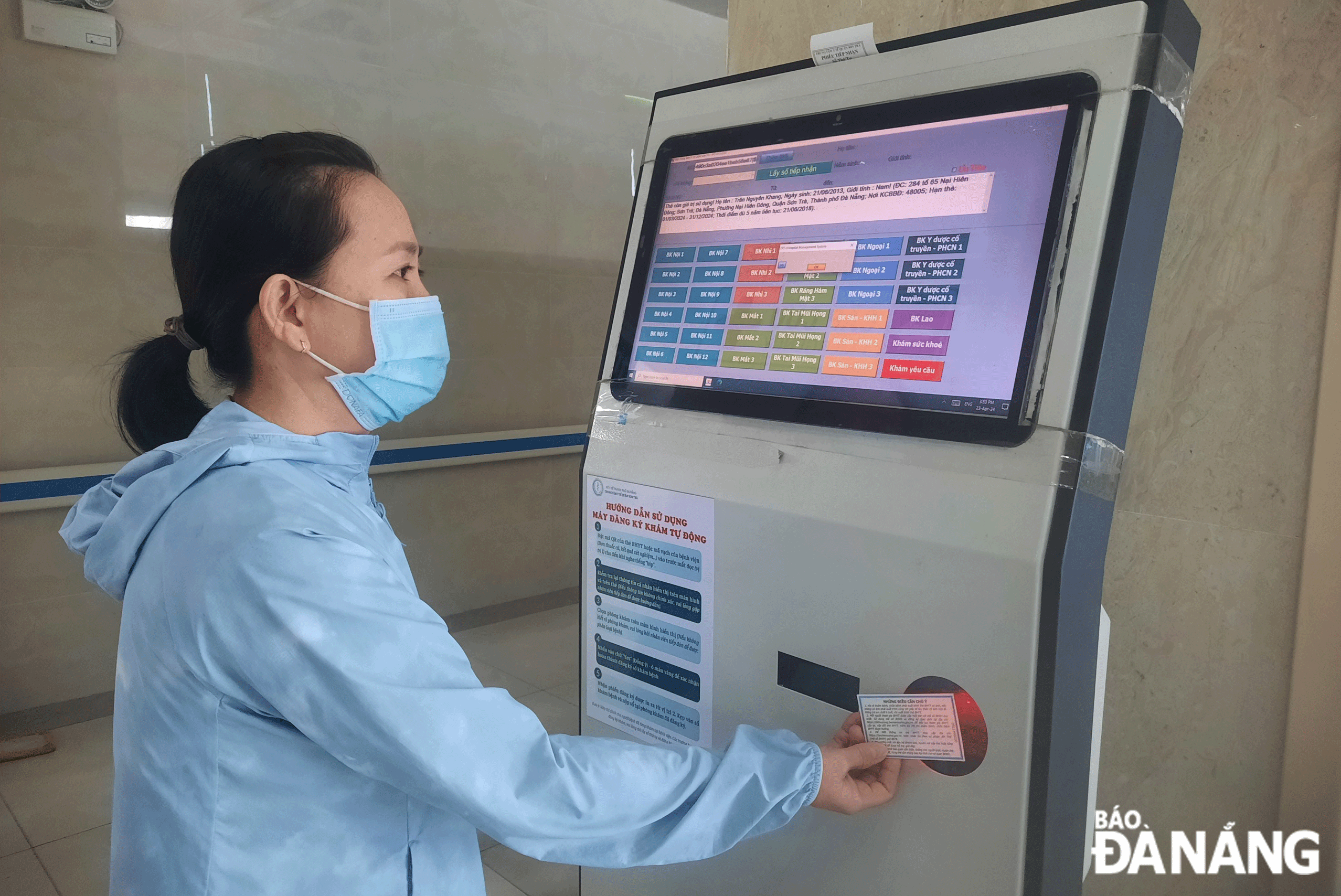 People scan their health insurance cards to register for automatic examination through the automatic reception kiosk at the Son Tra District-based Medical Centre. Photo: H.N