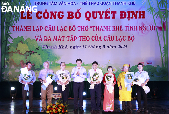 Phó Chủ tịch UBND quận Thanh Khê Nguyễn Hữu Công (thứ 4, từ trái sang) trao quyết định và tặng hoa cho Ban chủ nhiệm CLB thơ 