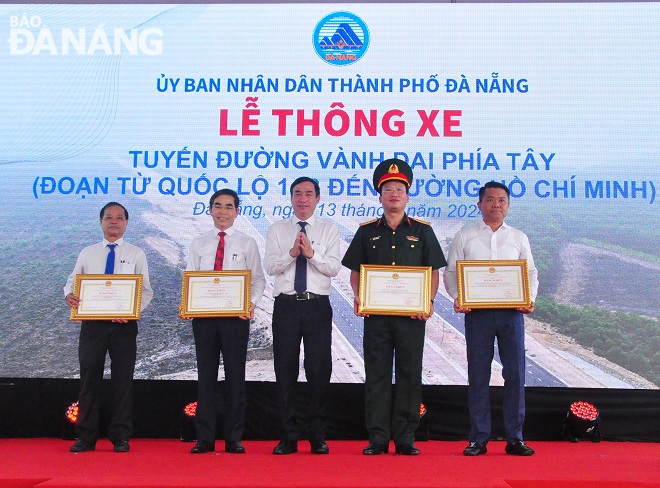 Chairman of the Da Nang People's Committee Le Trung Chinh (middle) giving Certificate of Merit to units in recognition of their outstanding achievements in construction, supervision, compensation and site clearance work. Photo: THANH LAN