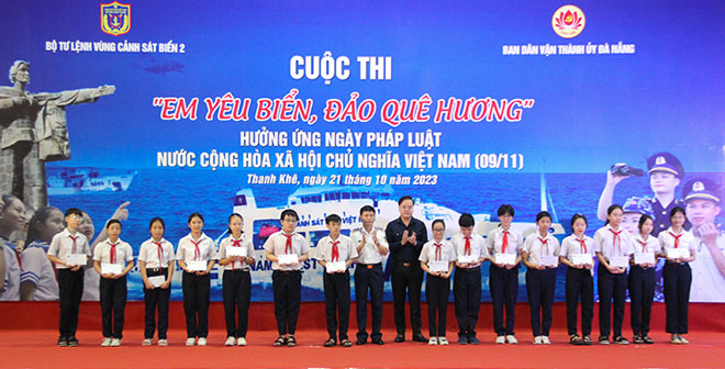 Đại diện Ban tổ chức cuộc thi “Em yêu biển, đảo quê hương” trao tặng học bổng cho các em học sinh quận Thanh Khê có hoàn cảnh khó khăn. Ảnh: Đ.H.L