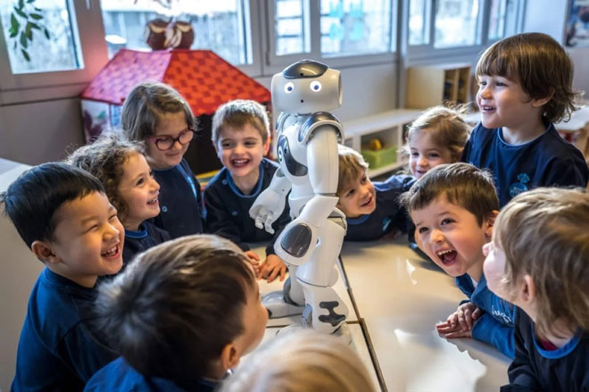 Các em nhỏ đang chơi đùa với robot tương tác và giáo dục Nao tại trường mầm non La Nanosphere. Ảnh: AFP