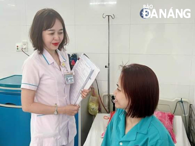 Chief nurse Nguyen Thi Thuy Van (left) checking on a patient's health