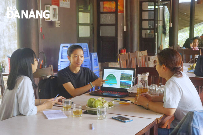 Nguyen Thi Lan Anh (middle) introduce the Hoa Bac Ecological Agriculture and Community-Based Tourism Cooperative to tourists. Photo: LAM VIEN.