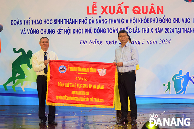 Standing Vice Chairman of the Da Nang People's Committee Ho Ky Minh (right) presenting the flag to leaders of the Department of Education and Training.