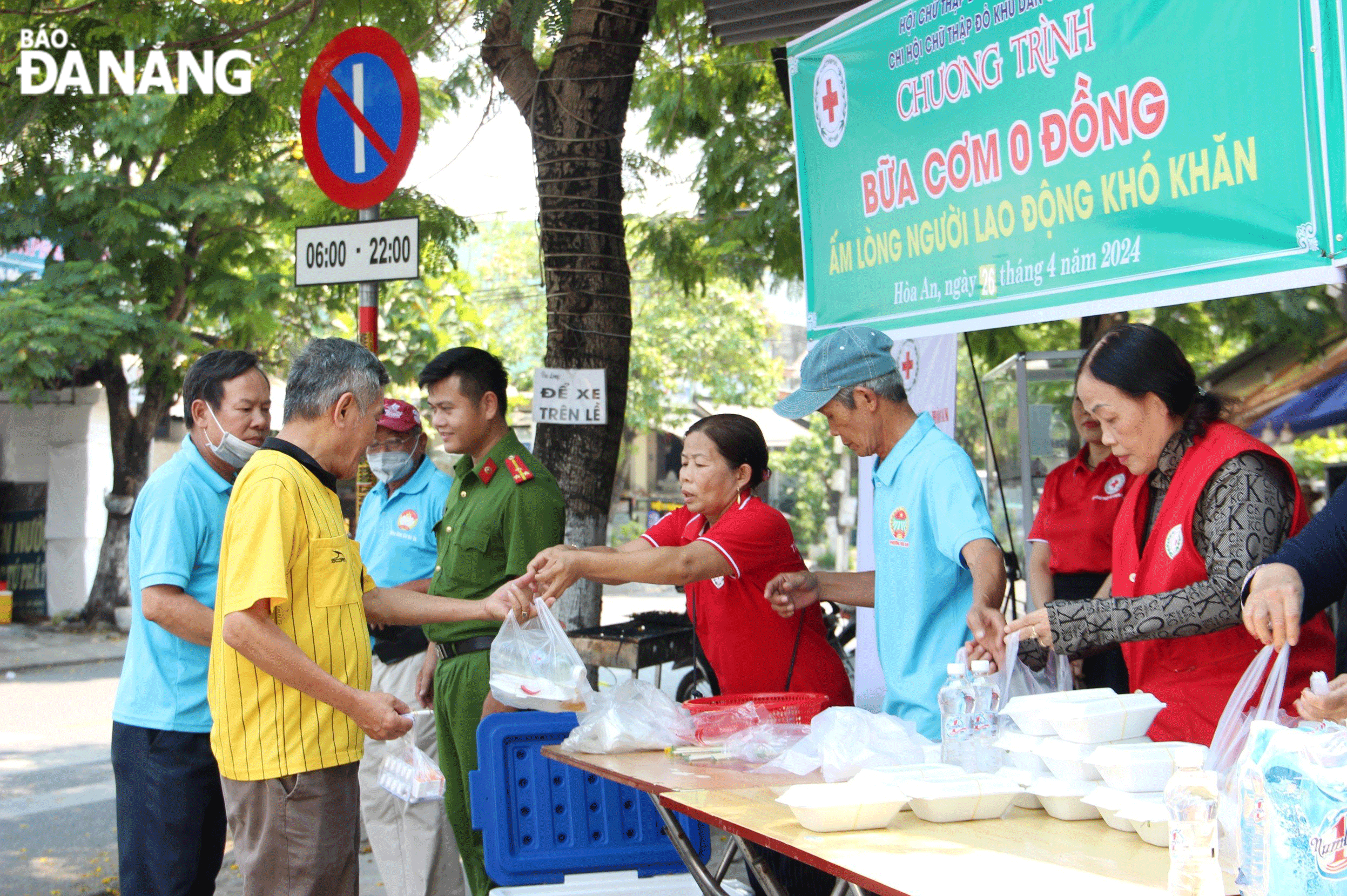 Cán bộ, hội viên Hội Chữ thập đỏ phường Hòa An (quận Cẩm Lệ) phát cơm cho người lao động nghèo trong khu vực. Ảnh: X.D	